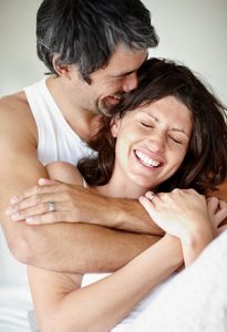 Portrait of mature couple enjoying themselves - Man embraces woman from back